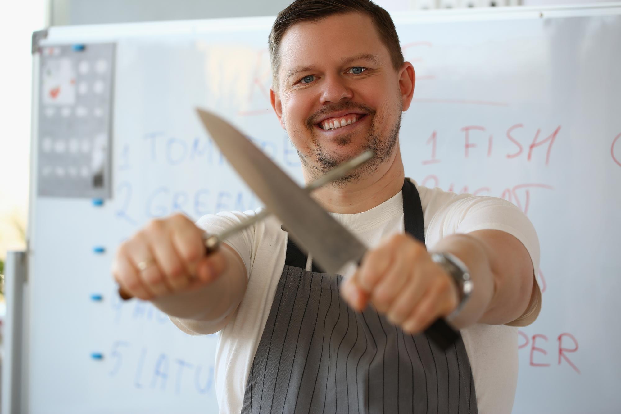 Instructor demonstrating knife technique to two students